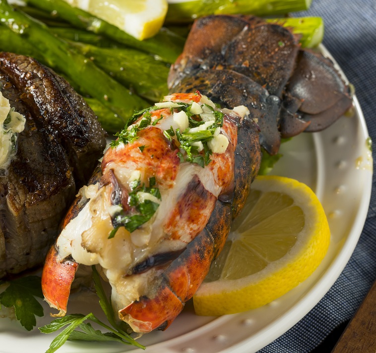 Plated lobster tail drizzled with herbed butter 